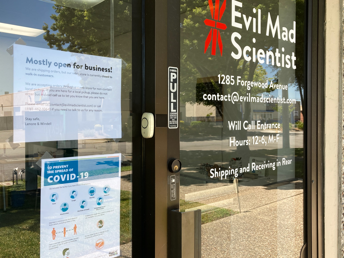 Evil Mad Scientist front door with signs about opening and COVID-19 requirements